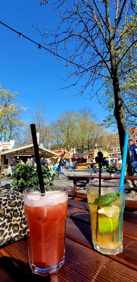 Zwei Cocktails auf einem Holztisch in der Frühlingssonne