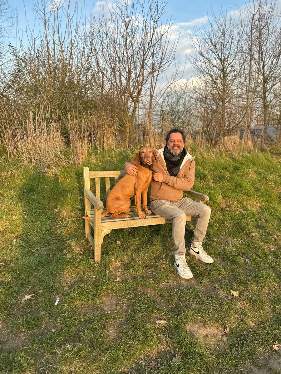 Claus und Carl, der Vizsla, auf einer Holzbank in der Abendsonne